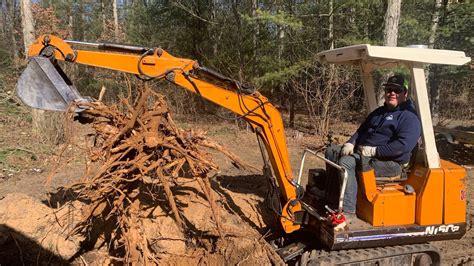 removing large stumps with mini excavator|digging stumps with mini excavator.